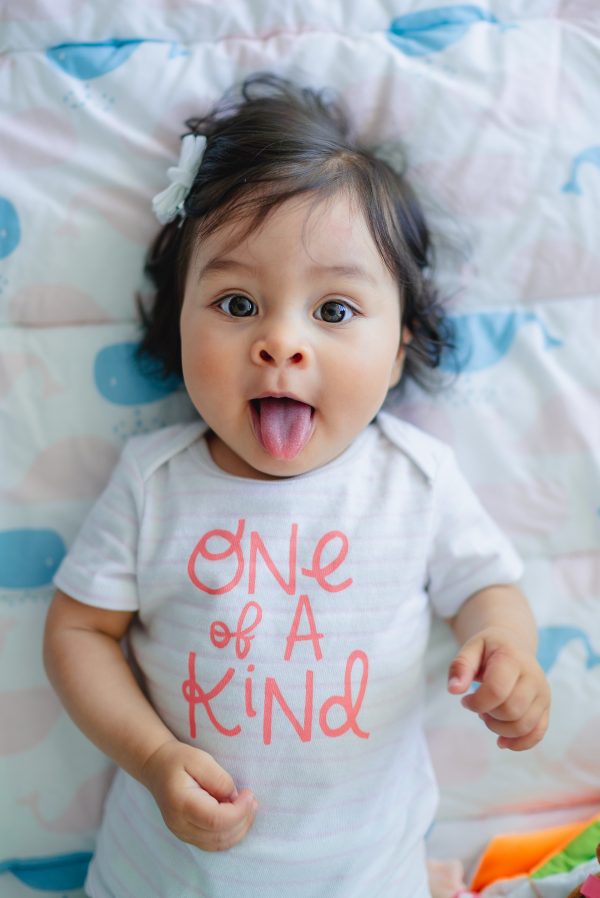 Wide eyed baby sticking her tongue out.